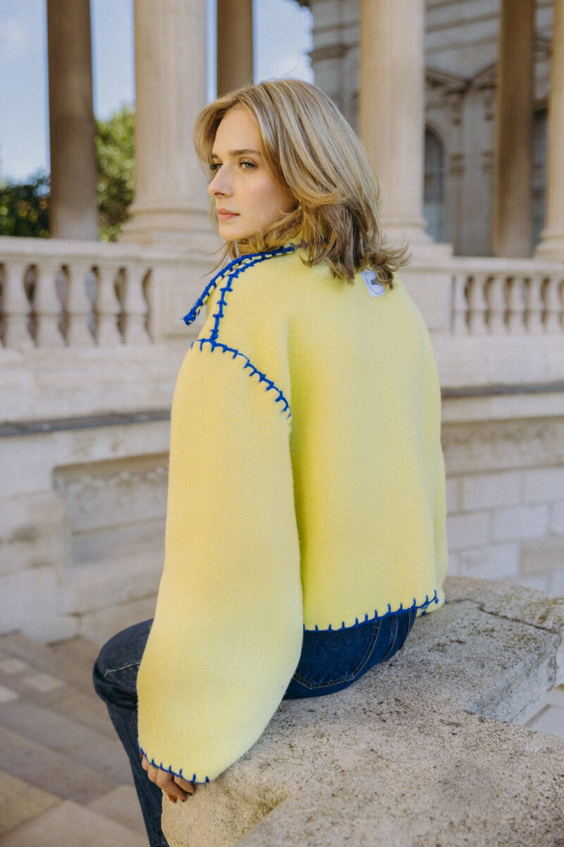 veste en laine jaune clair, détails à la main en laine bleu